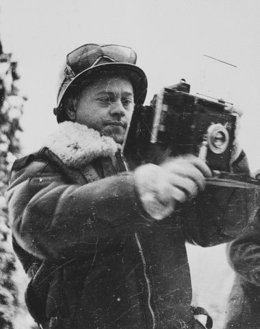 Mickey Rooney poses holding a Signal Photo Company Speed Graphic camera during his visit to the ETO (European Theatre of Operations)..jpg